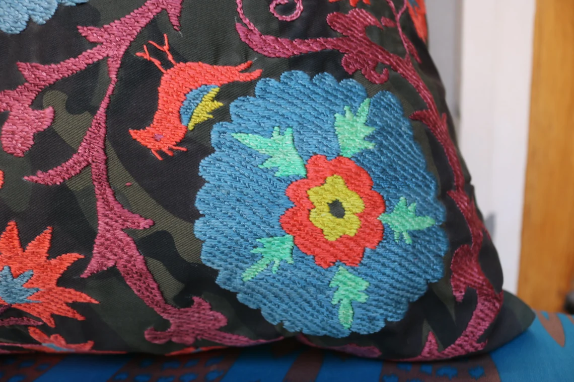 Suzani pillowcase covers are traditional Uzbek textiles, hand-embroidered with vibrant floral and geometric patterns.